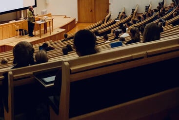 large mostly empty lecture hall with professor at front