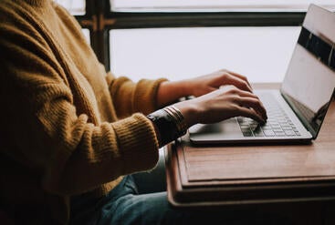 person typing on laptop keyboard