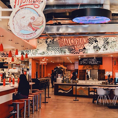 Two fruit ice cream bars; one is pink and the other is white with slices of strawberry, kiwi and peach.