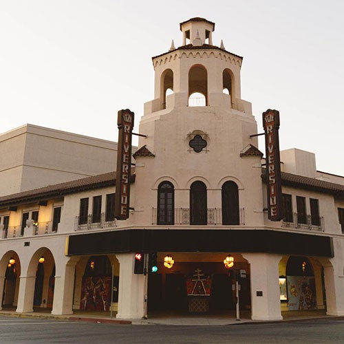 Colorful sunset atop a lake at Fairmount Park with silhouettes of palm trees.