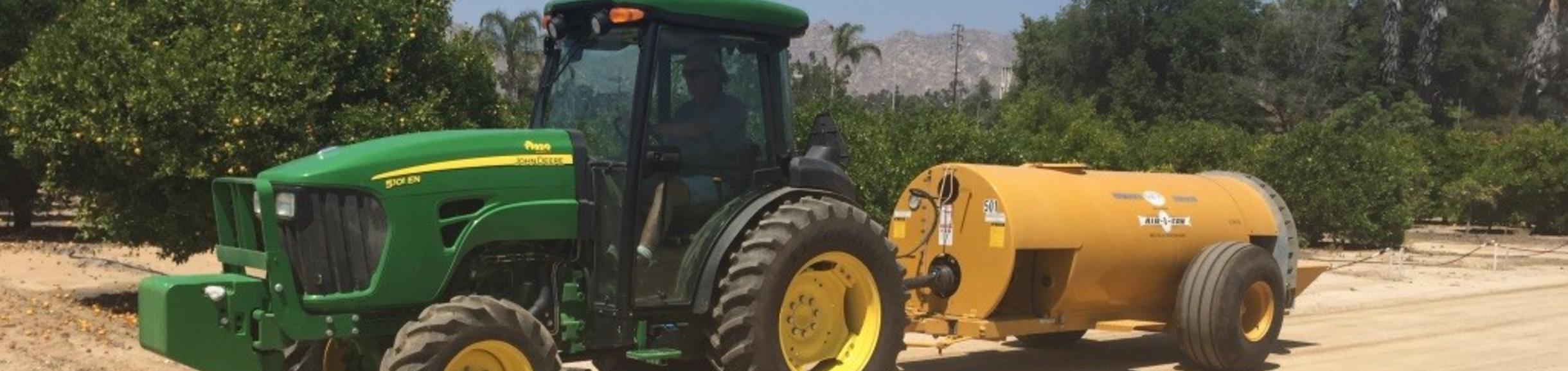 Tractor on road with sprayer attached