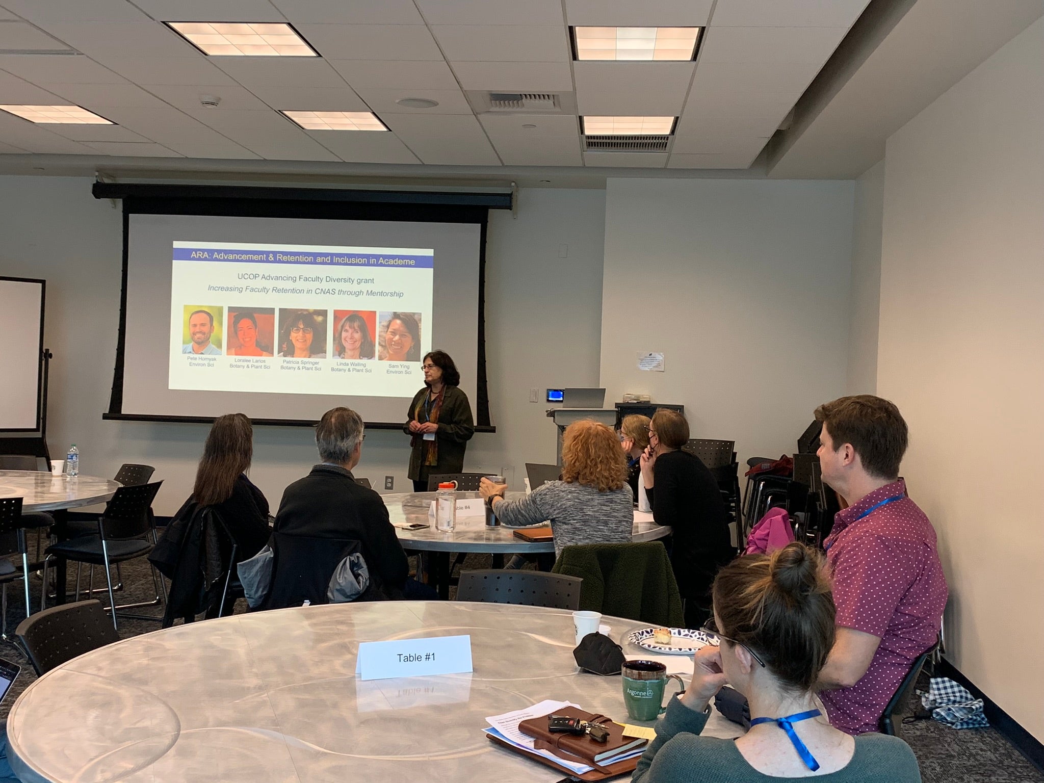 people sitting at tables listening to a presentation