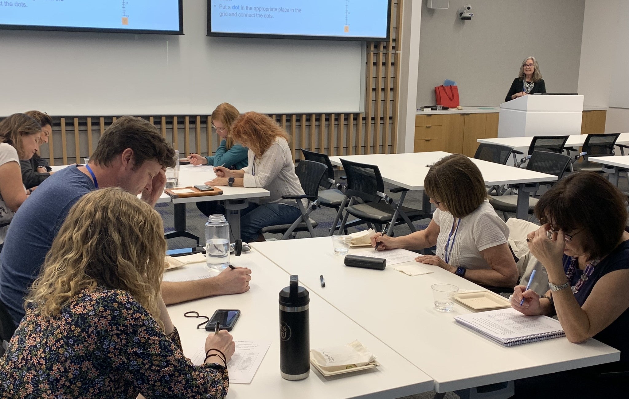 people sitting at tables working on assignment