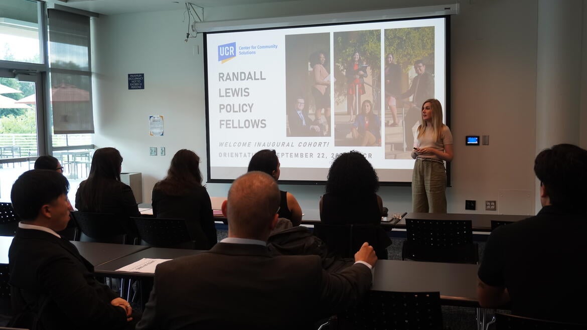 A class of fellows sitting in front of a projector