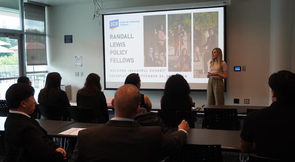 A class of fellows sitting in front of a projector