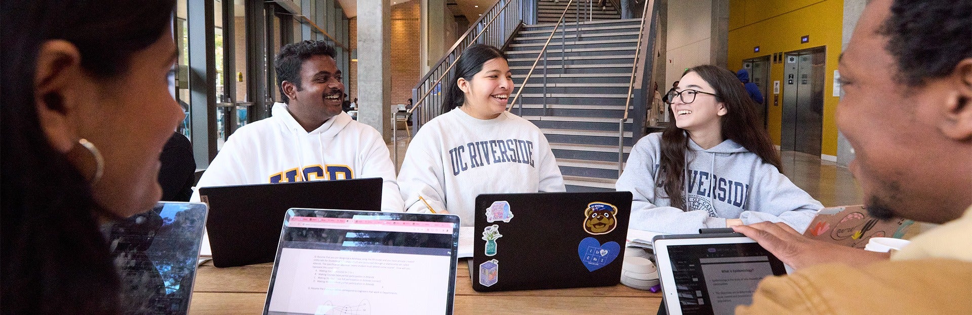 CNAS Students sitting at a table with laptop computers.