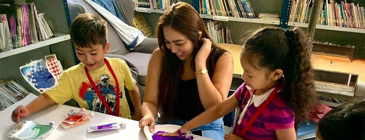 Wendy Romero ’19 BA ’22 MBA, founder and CEO of Love 4 Life, works with children as part of an annual outreach in Mexico, helping children make pledges not to bully.