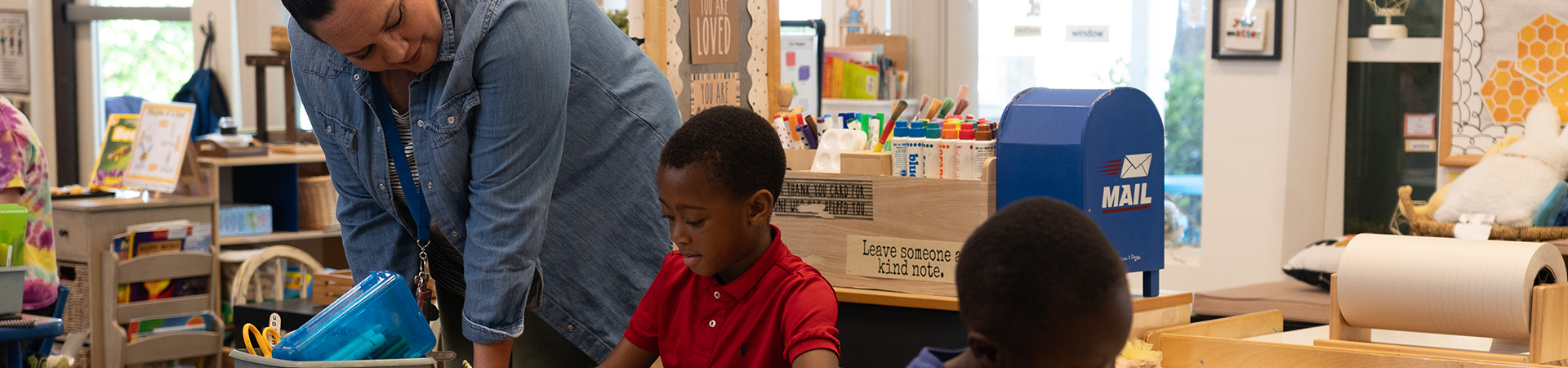 teacher helping kindergartener with work