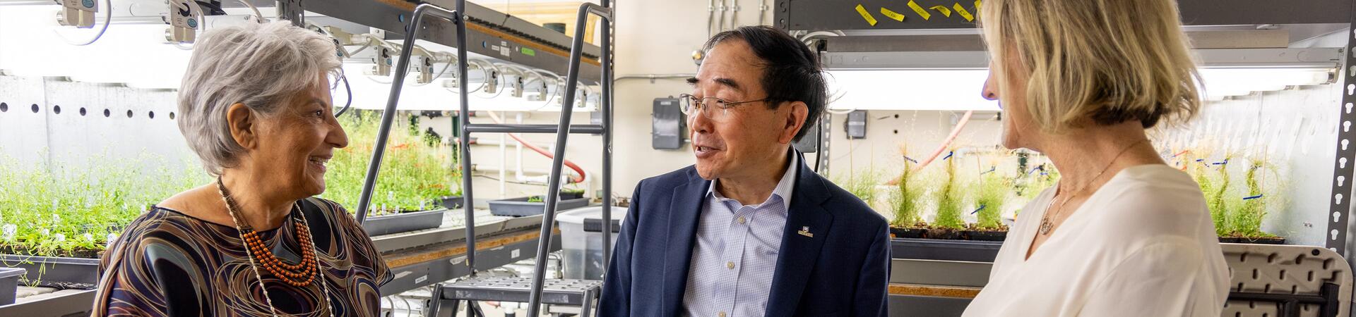 Chancellor S. Jack Hu, center, talks with professors Katie Dehesh, left,  and Julia Bailey-Serres