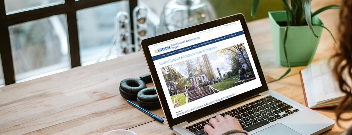 A UCR students looks at the Student Conduct & Academic Intergrity Programs website on their laptop.