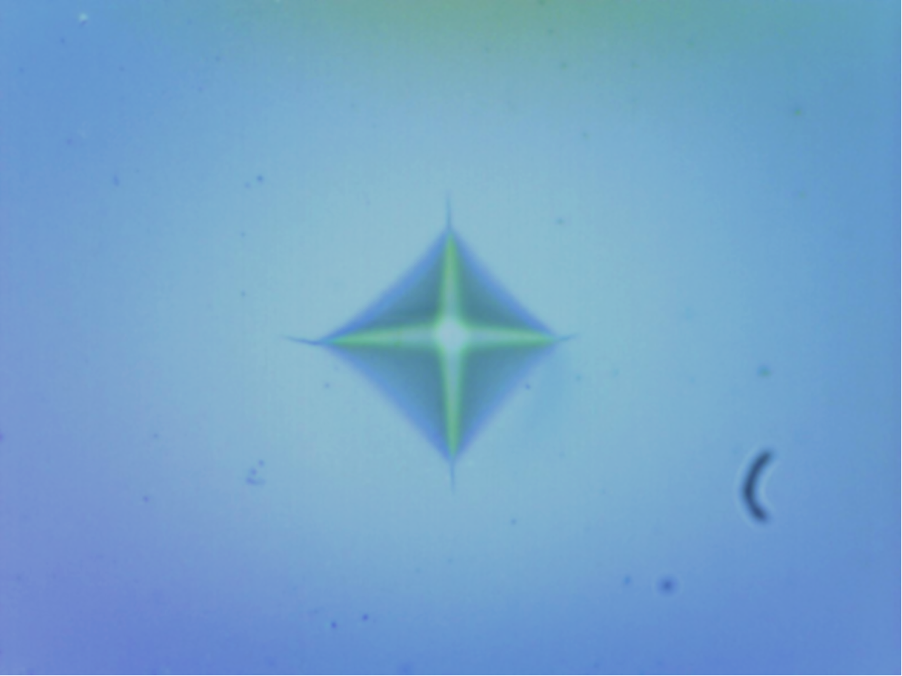 Indentation in ceramic sample for measurement of Vickers hardness.