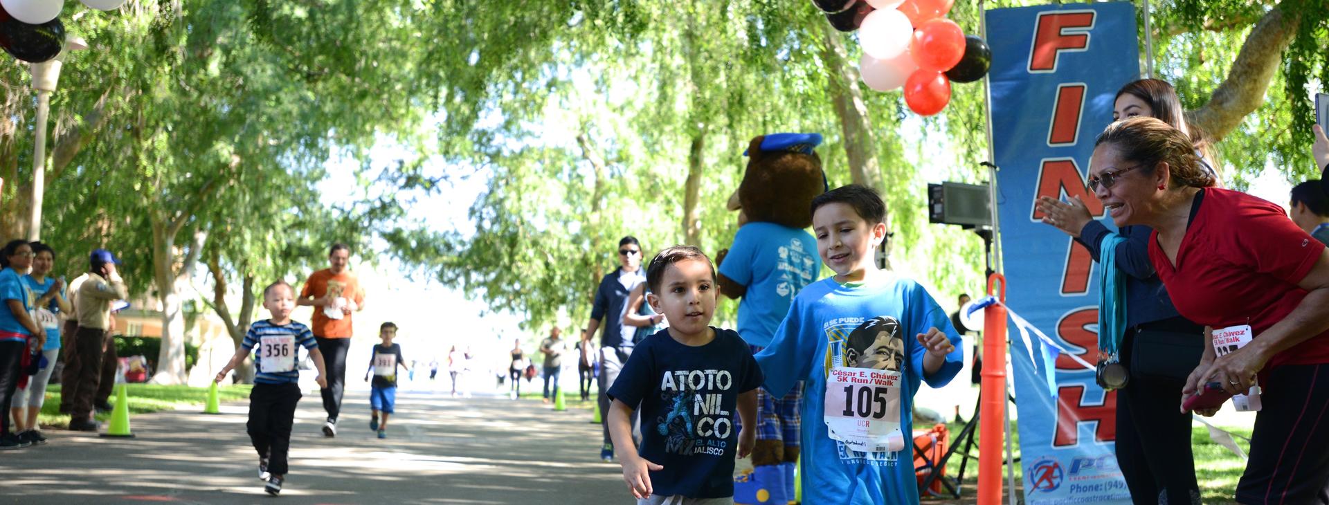 Two little kids running in the Cesar E.Chavez 5K Run/Walk event