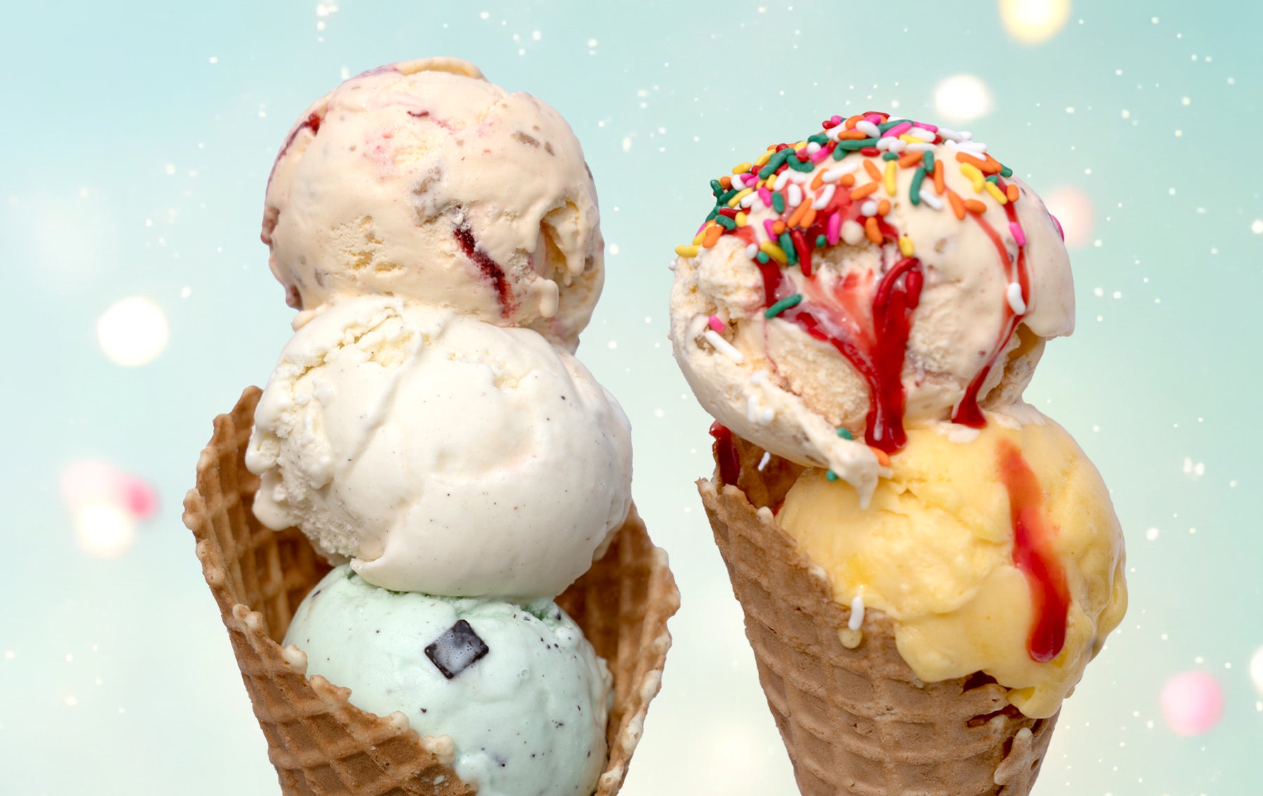 two scoop ice cream cone with sprinkles and strawberry syrup and three scoop ice cream cone with mint, vanilla, and strawberry