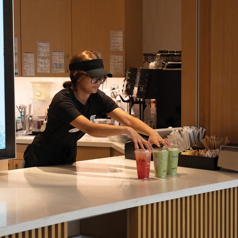 student employee serves Biz Cafe drinks