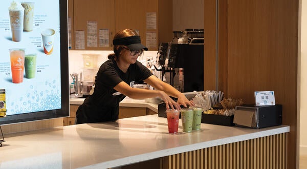 student employee serves Biz Cafe drinks