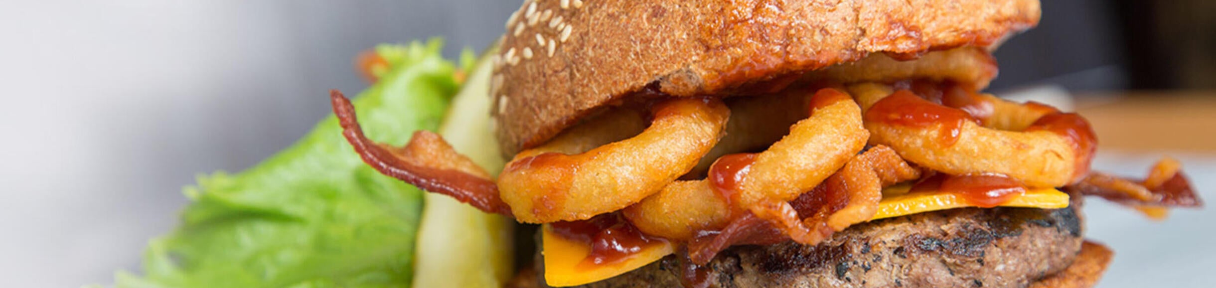Close-up of hamburger with onion rings on it