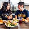 Two students laugh while eating at Lothian.