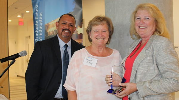Interim Dean, Louie Rodriguez and presenter and GSOE alumna, Sharon Duffy pose with Distinguished Alumni Honoree, Beverly Young