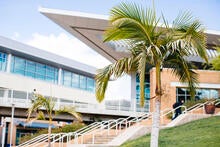 researcher sitting on a stool wearing ppe in front of equipment