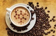 A cup of coffee with a molecular pattern drawn into the foam. 