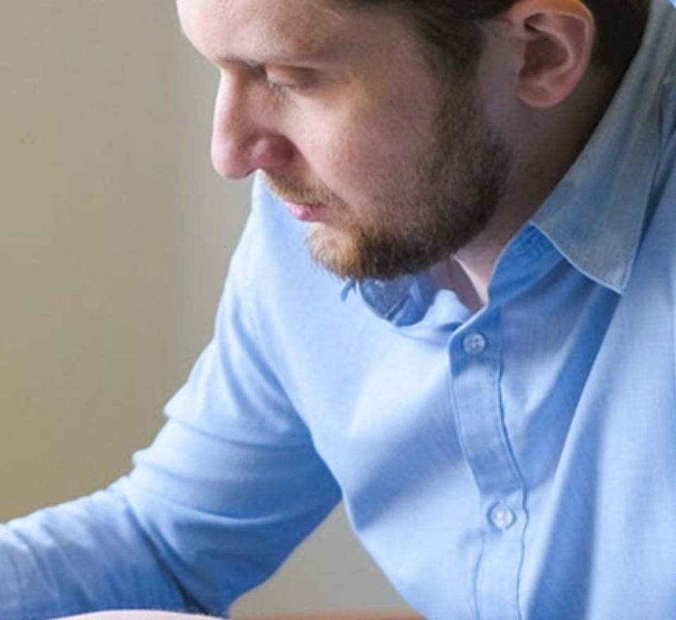 Man in blue shirt writing on desk