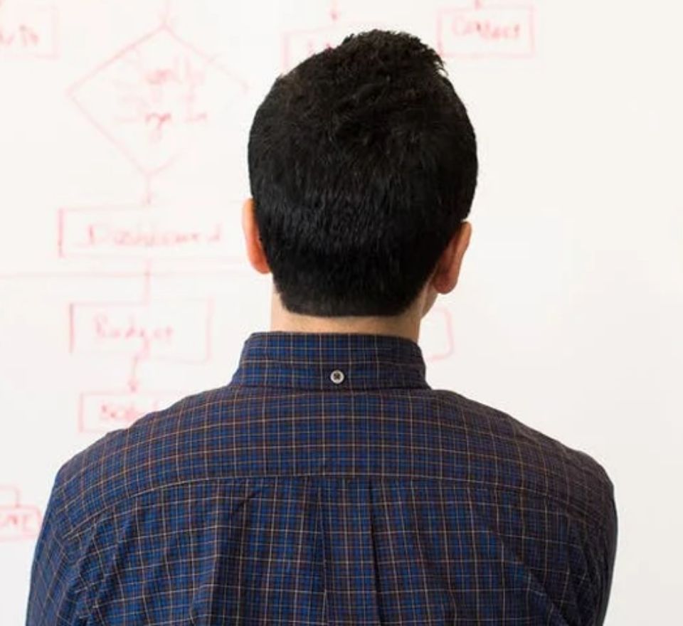 Professional man looking at white board as he ponders his engineering project