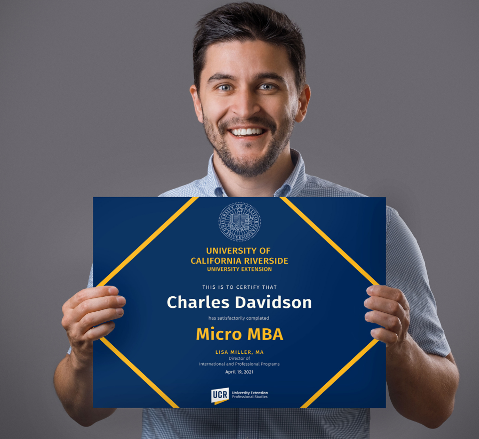 Young Hispanic male proudly holding a professional certificate of completion