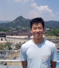 Young asian man standing in front of the blue house in korea