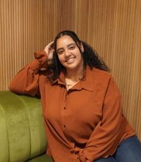 UCR University Extension graduate Sahara Powell casually sitting on couch