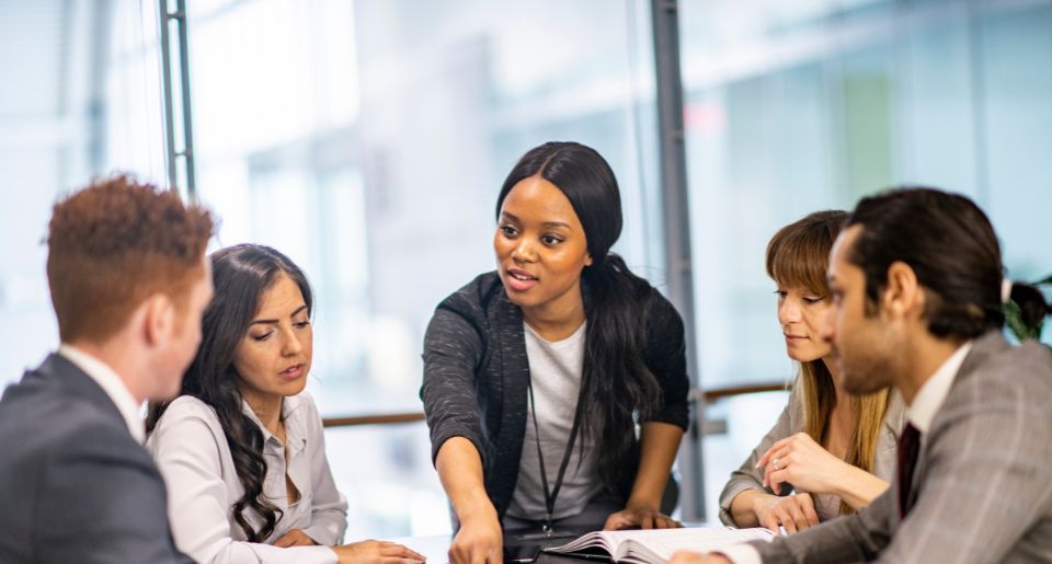 Businesswoman running a meeting with four of her staff members