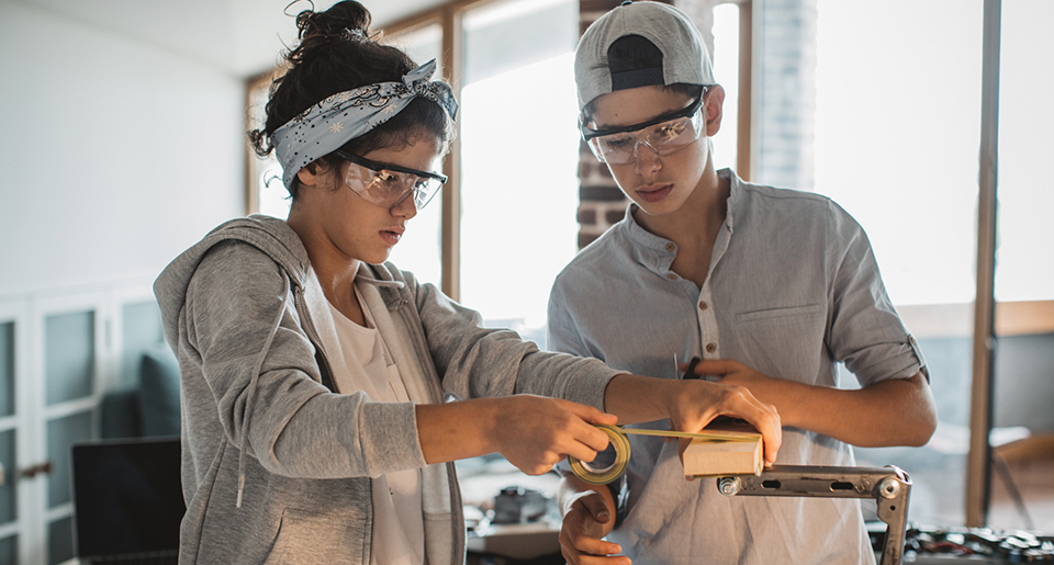 White highschool girl and boy woking on a project in a classroom