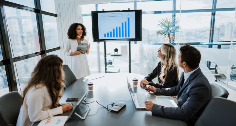 Professional woman standing in front of colleagues giving a presentation