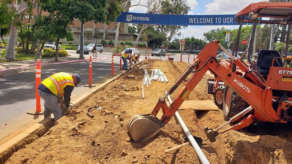 Landscapers digging trench for irrigation by hand and with equipment