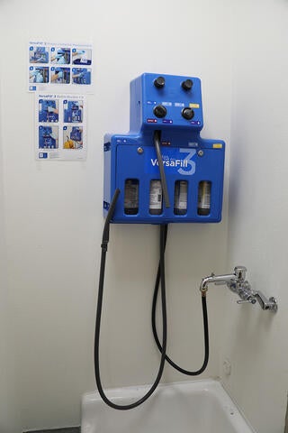 A blue box on a wall connected to a faucet