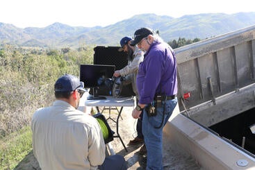 Plant operators with tv equipment outside a TES tank
