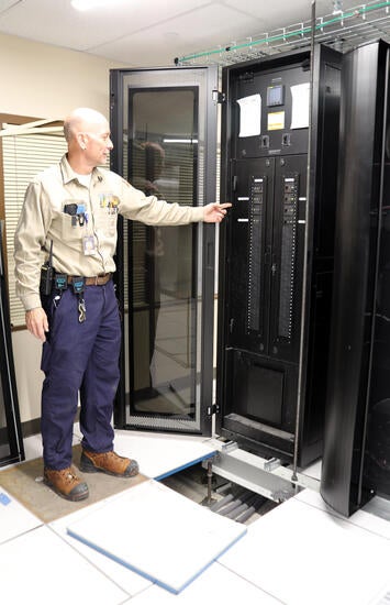 Electrician pointing to UPS switches