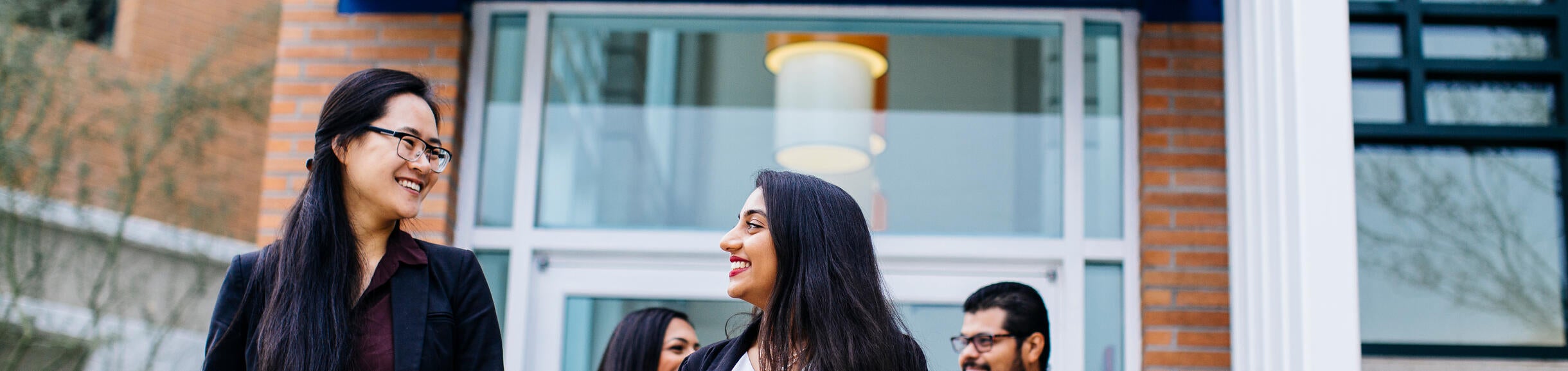 Students dressed in business attire walk away from the Career Center in the background.