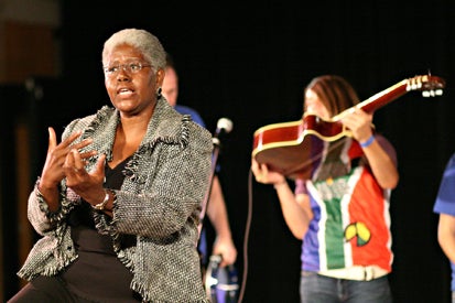 female storyteller with musicians in the background