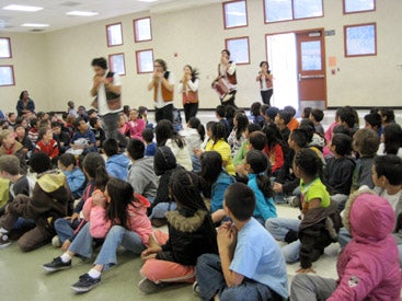 music ensemble performing for a group of seated students