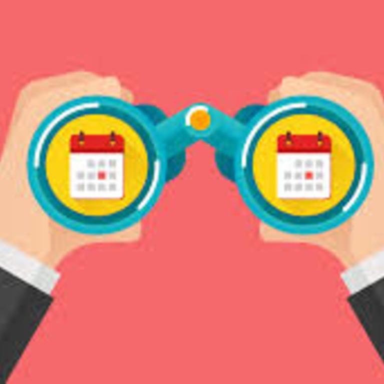 Hands holding up binoculars looking at a calendar 