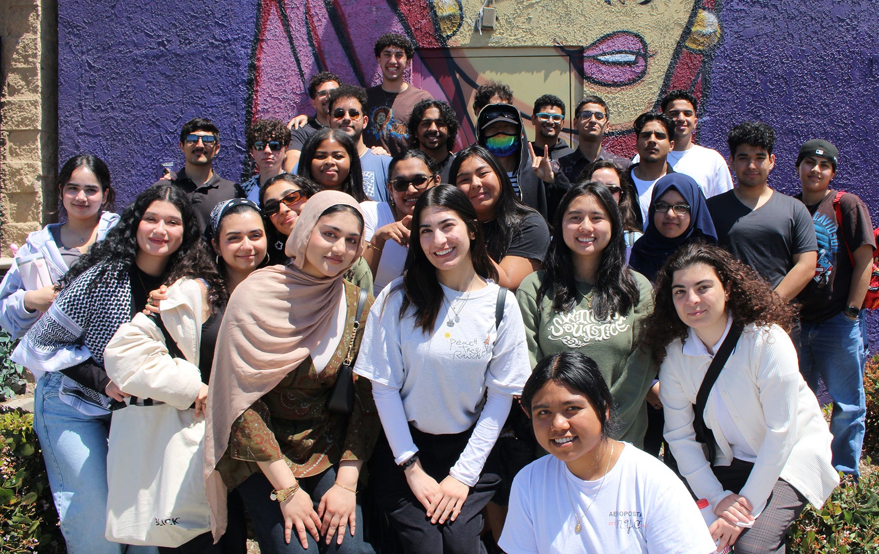 student group shot in front of mural