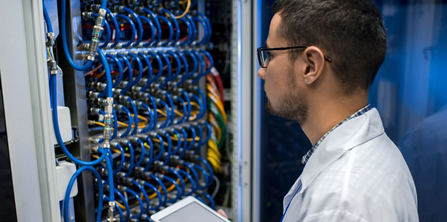 A man looking a many blue wires