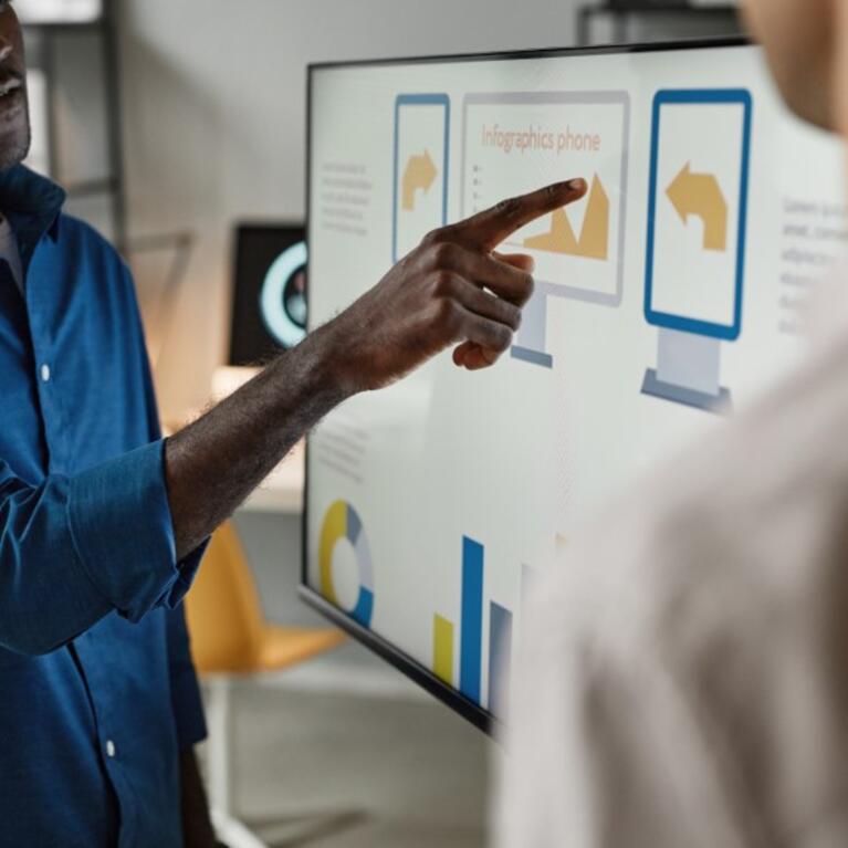 A man looking at a screen and pointing things out in a presentation