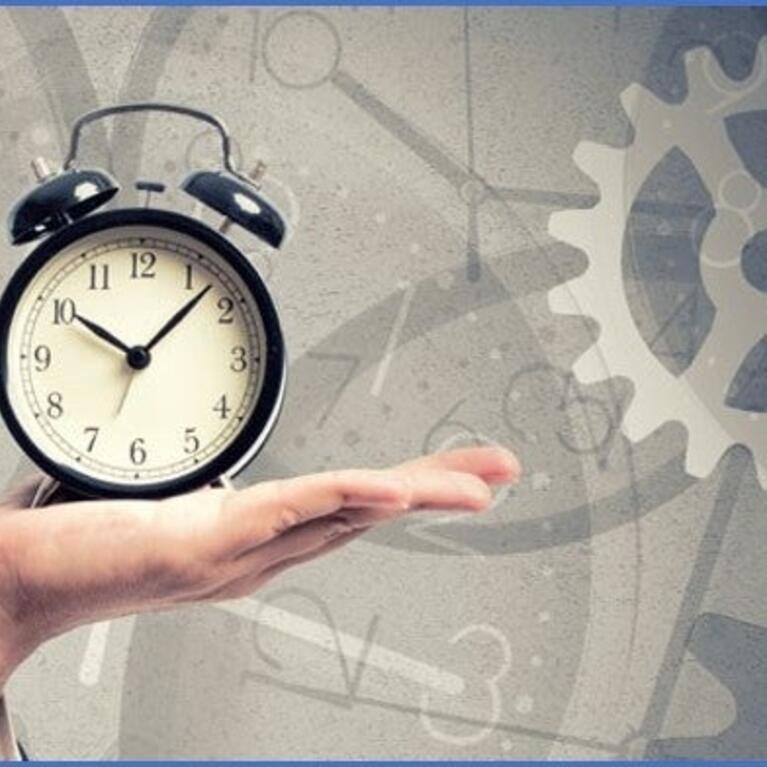 A person holding a clock in hand