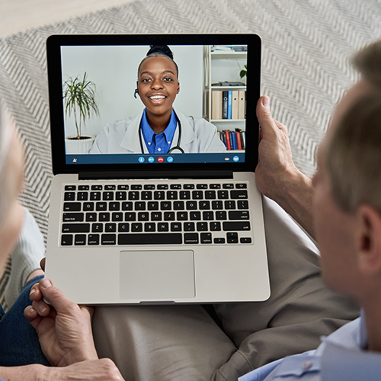 A mature couple looking at a laptop for and online appointment