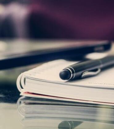 A notebook with a pen on it