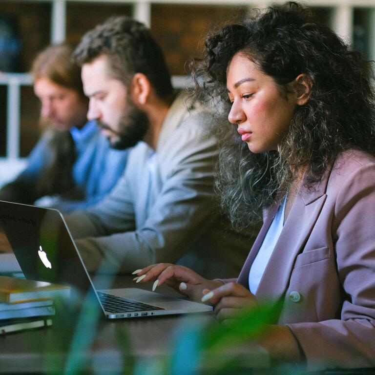 three employees on a laptop