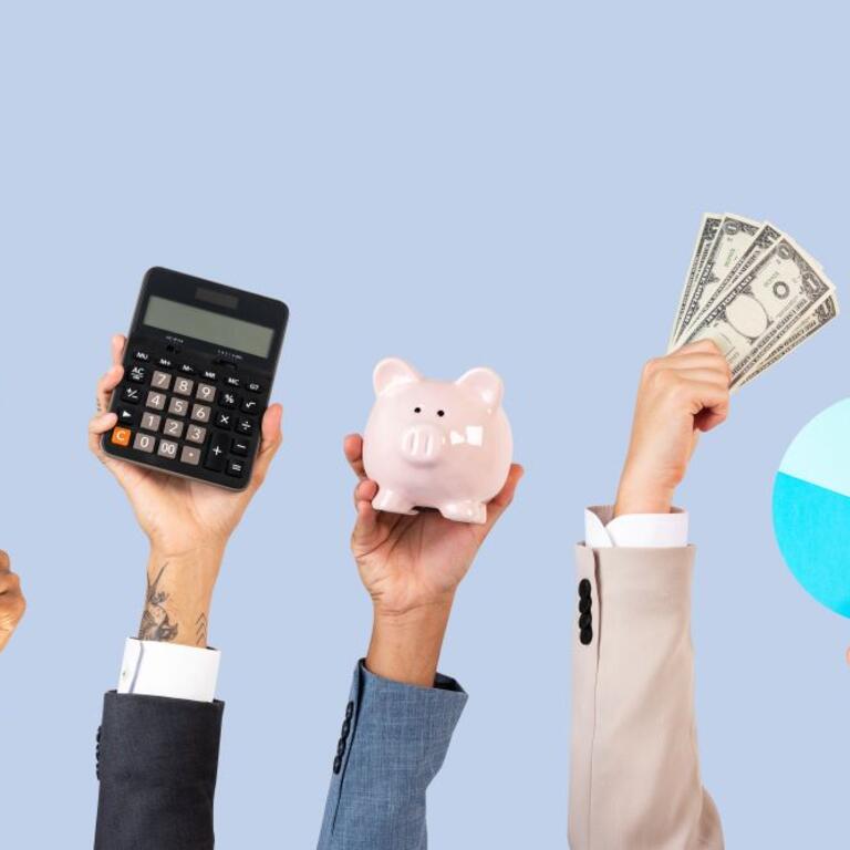 five hands holding up a magnifying glass, calculator, piggy bank, money and a pie chart