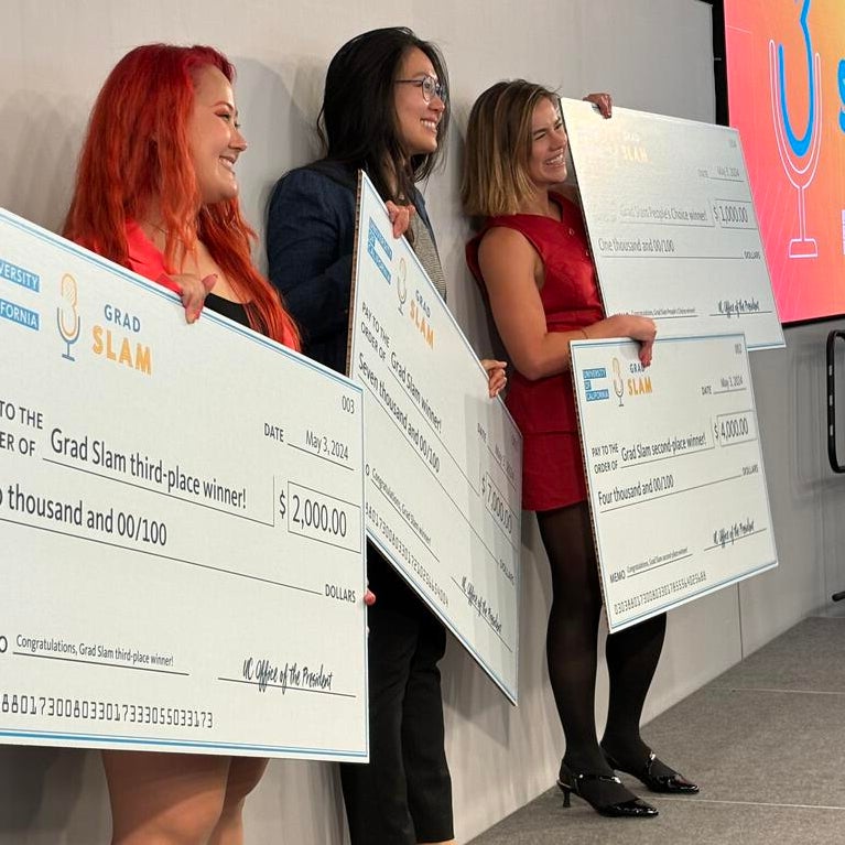 UC Grad Slam winners holding giant award checks