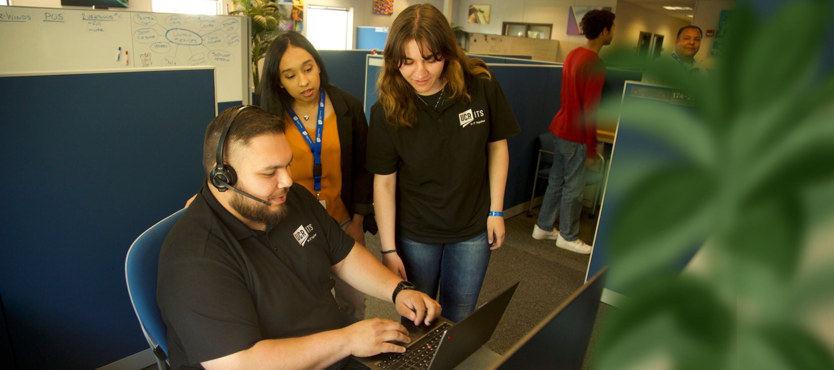 two ITS staff employees point at computer screen